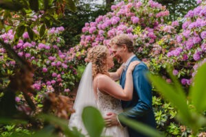 trouwshoot tussen roze bloemen bruidspaar