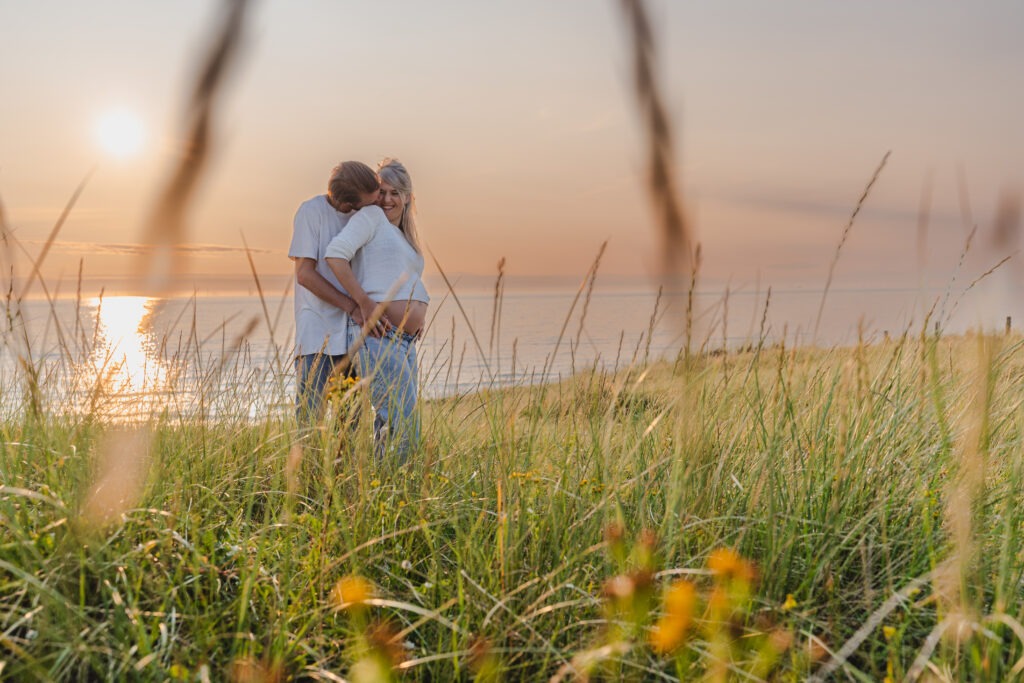 Koppel geniet van een liefdevolle zwangerschapsshoot in het zonlicht