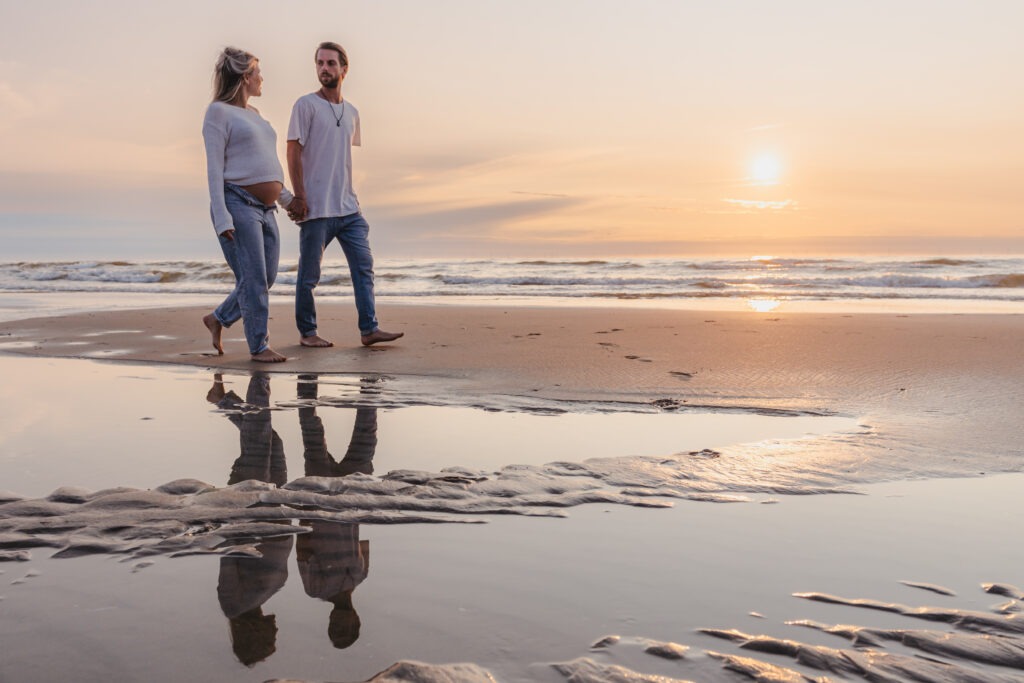 Koppel geniet van een liefdevolle zwangerschapsshoot aan zee